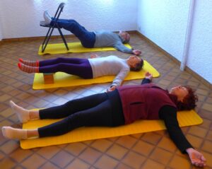 Exercice de relaxation pour détendre le diaphragme à plat sur le dol en relevant les jambes sur un petit banc ou sur une chaise-Yvette Clouet-Marseille-5e